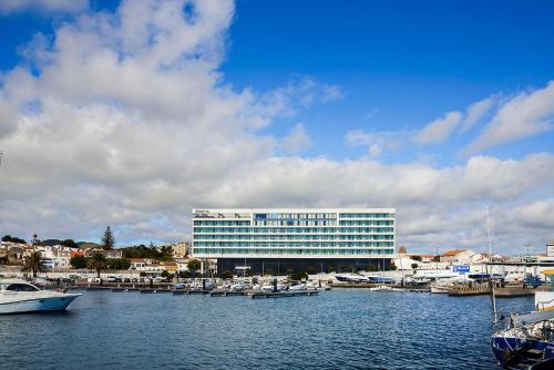 a large white building with boats in a harbor at Octant Ponta Delgada in Ponta Delgada