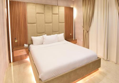 a large white bed in a room with a window at الدرة للشقق الفندقية in Kuwait