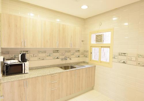 a kitchen with a sink and a microwave at الدرة للشقق الفندقية in Kuwait