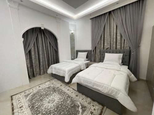 1 dormitorio con 2 camas y alfombra en Alhawameir rest, en Wāsiţ