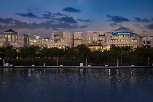 a large building next to a large body of water at Wyndham Grand Jupiter at Harbourside Place in Jupiter