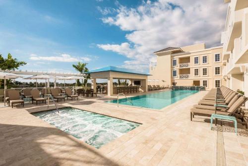 a pool at a hotel with lounge chairs and a resort at Wyndham Grand Jupiter at Harbourside Place in Jupiter