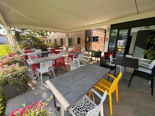 a patio with a table and chairs and a piano at Campanile Metz Nord - Woippy in Woippy