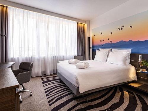 um quarto de hotel com uma cama e uma grande janela em Novotel St Petersburg Centre em São Petersburgo