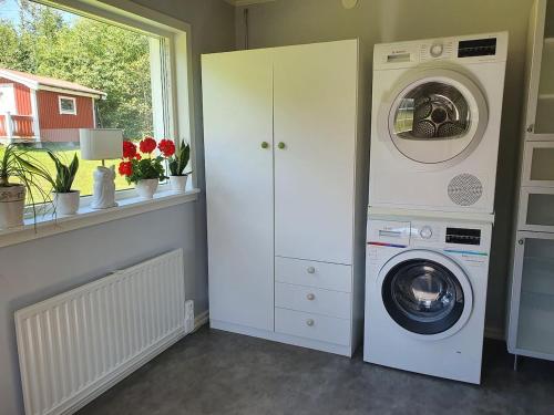 a laundry room with a washer and dryer next to a window at Ytterfalle 169 in Härnösand