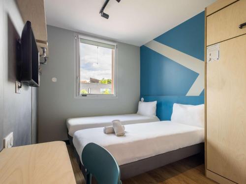 Postel nebo postele na pokoji v ubytování ibis budget Nanterre la Defense