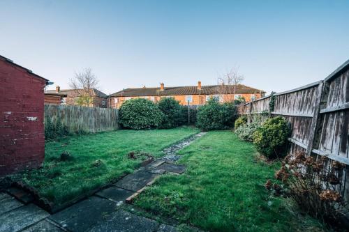 a yard with a fence and green grass at Tranmere House Workstays UK Best Rates Direct in Middlesbrough