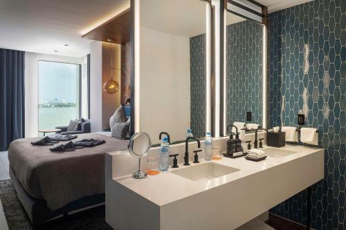 a bathroom with a sink and a large mirror at Canopy By Hilton Cancun La Isla in Cancún