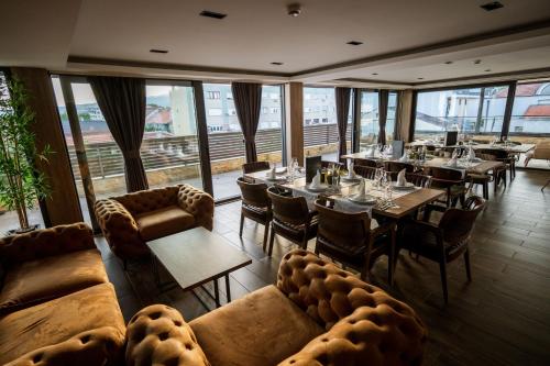 a dining room with tables and couches and windows at Bed and Breakfast Ponte Bianco in Vranje