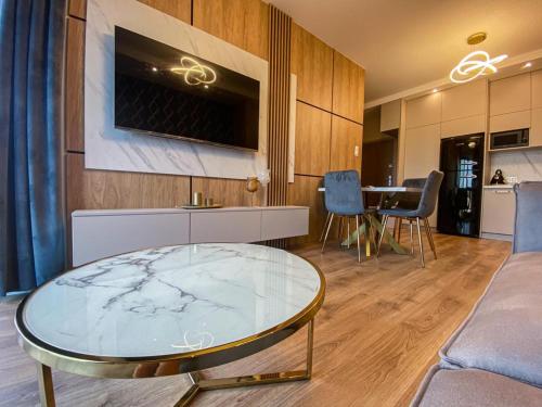 a living room with a glass table and a kitchen at apartament u Kasi in Ełk