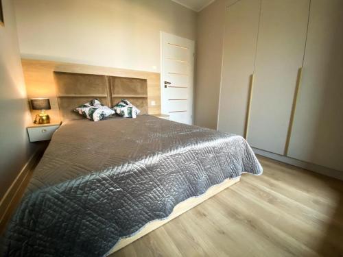 1 dormitorio con 1 cama grande y suelo de madera en apartament u Kasi, en Ełk