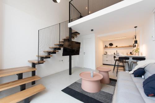 a living room with a couch and a staircase at PORT CITY HAIFA - Urbanic Loft in the Heart of Haifa's Downtown in Haifa