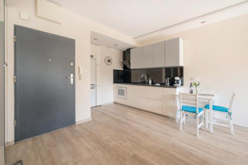 a kitchen and dining room with a table and chairs at Orientarium Business Apartments with Parking by Rentujemy in Łódź