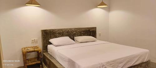 a bed with two pillows and a mirror in a room at Mengalung Bungalow in Kuta Lombok
