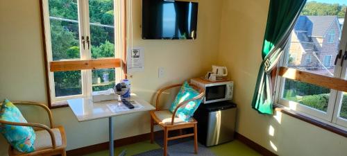 a small room with a table and a microwave at JOYinn in Ito