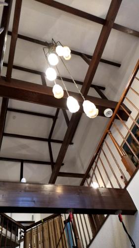 a ceiling with wooden beams and lights on it at JOYinn in Ito