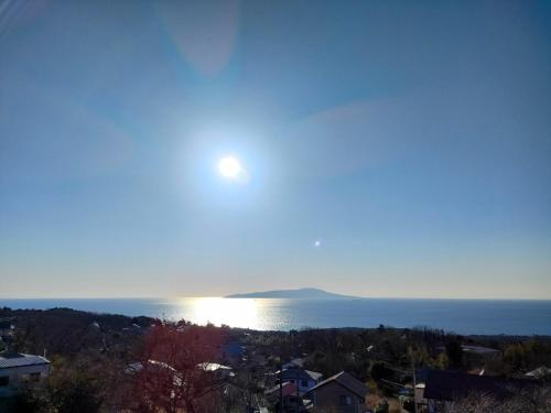 a view of the ocean with the sun in the sky at JOYinn in Ito