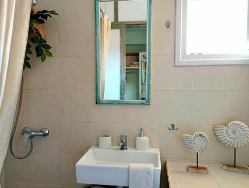 a bathroom with a sink and a mirror at Ammoudara's apartments Rooftop in Kalymnos