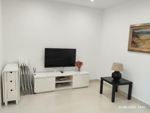 una sala de estar blanca con TV en una pared blanca en Apartamento Agradable1 en Madrid
