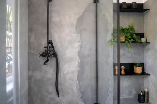 a shower in a bathroom with a concrete wall at Vila Heide in Česká Kamenice