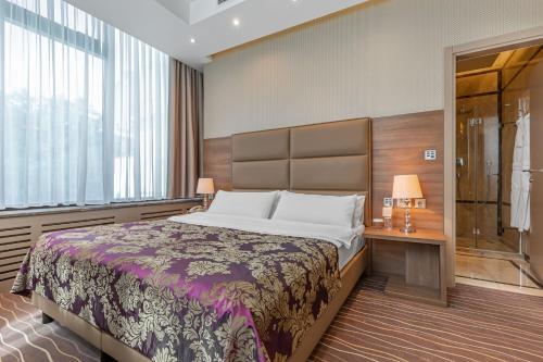 a bedroom with a large bed and a shower at Khreschatyk Hotel in Kyiv