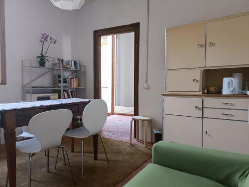 un soggiorno con tavolo e sedie e una cucina di La Capinera a Muggio