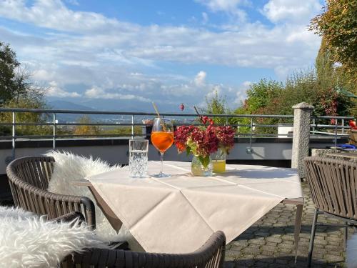 een tafel met 2 wijnglazen en bloemen op een balkon bij Landgasthof Bogner in Absam