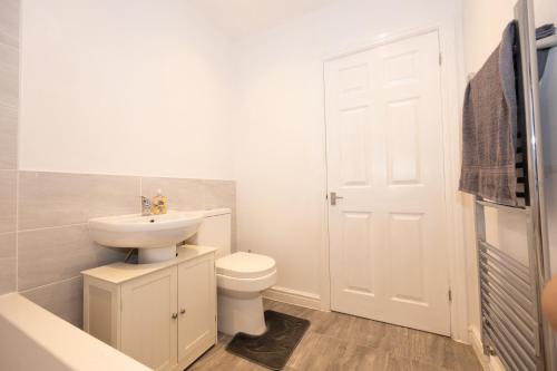 a white bathroom with a toilet and a sink at Good Location Free Parking Contractor Leisure in Atherton