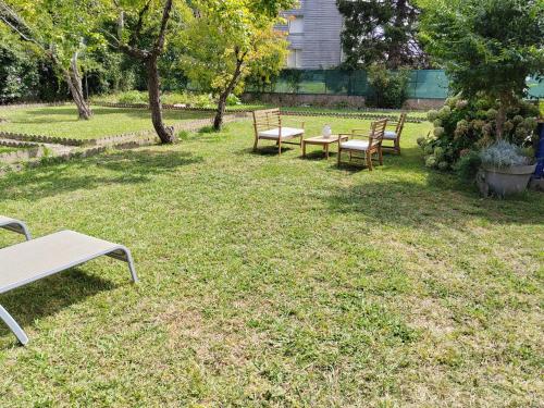 a group of benches sitting in the grass at Emplacement nu sur Bayonne pour tentes dans jardin clos et privé in Bayonne