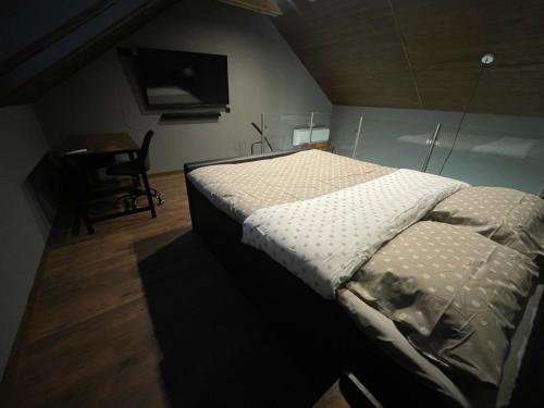 Schlafzimmer mit einem Bett, einem Schreibtisch und einem TV in der Unterkunft Domek przy lesie z basenem in Jędrzejów