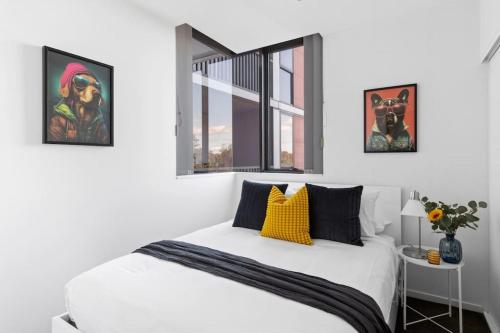 a bedroom with a white bed and a window at Urban Uptown: Stylish Richmond in Melbourne