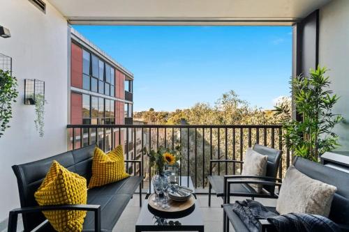 a patio with two couches and a table on a balcony at Urban Uptown: Stylish Richmond in Melbourne