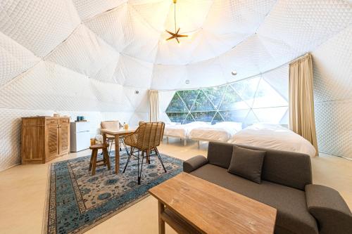 a bedroom with a domed ceiling with a couch and a table at Innocence Resort -in Chiba Resol- in Hasunuma