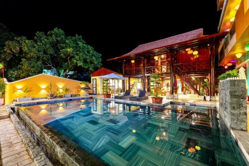 una piscina di fronte a una casa di notte di Trang An Ao Dai Homestay a Ninh Binh