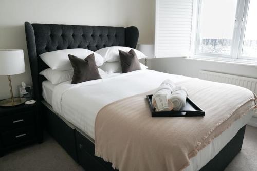 a bed with a tray with two towels on it at Stunning modern space with harbour views & free parking in Brighton & Hove
