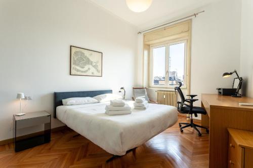 a bedroom with a bed with a desk and a chair at Garibaldi Two Bedrooms in Milan