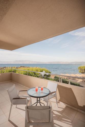 a balcony with a table and chairs and the ocean at Molos Bay Hotel in Kissamos