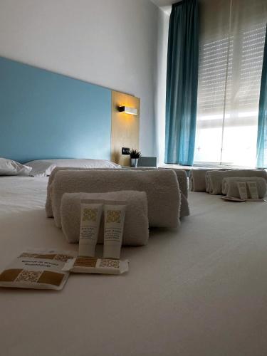 a bedroom with a bed with three books on the floor at Hotel Grecale - Venturina Terme in Venturina Terme
