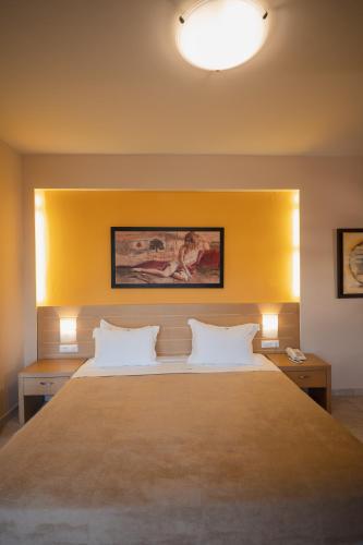 a bedroom with a large bed with a yellow headboard at Molos Bay Hotel in Kissamos