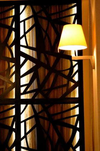 a lamp next to a window with a curtain at Evridiki in Kilkís