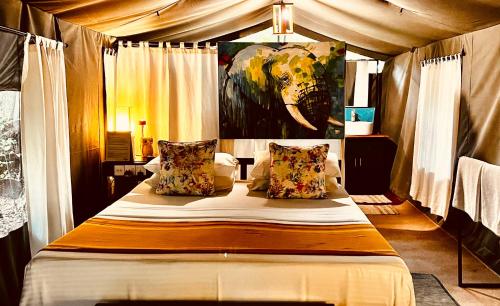 a bedroom with a bed with a painting of an elephant at Mahoora Wilpattu - by Eco Team in Wilpattu
