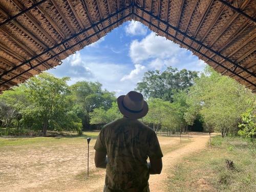 a man in a hat looking at the sky at Mahoora Wilpattu - by Eco Team in Wilpattu