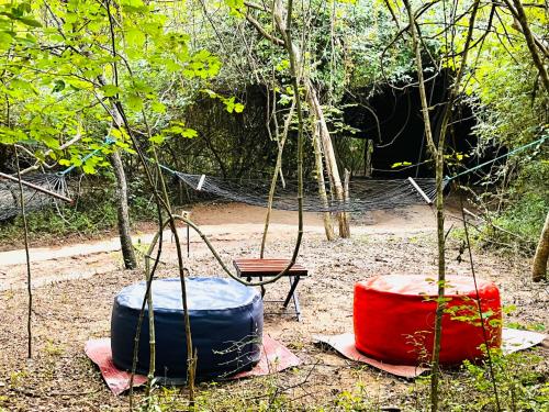 a group of three colored barrels and a swing at Mahoora Wilpattu - by Eco Team in Wilpattu