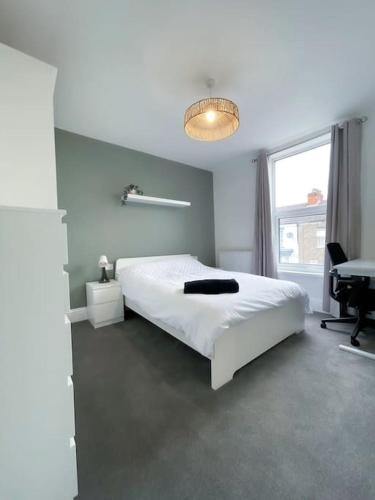 a white bedroom with a white bed and a desk at Newly refurbished 3 bed house in Hull