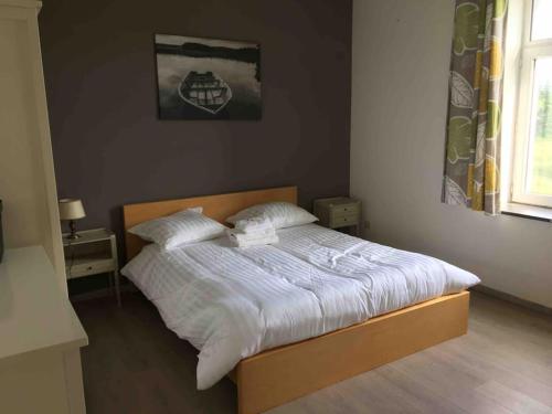 a bed with white sheets and pillows in a bedroom at La Casa Kemtio in Nollevaux