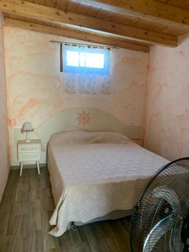 a small bedroom with a bed and a window at Santa maria in Olbia