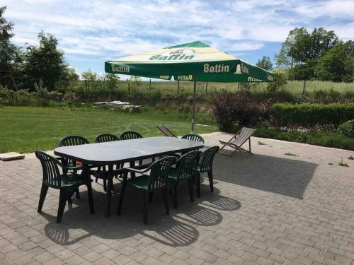 a table and chairs with a green umbrella at La Casa Kemtio in Nollevaux