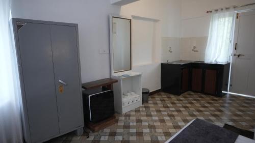 Anjoned Hostel & Cafe في أنجونا: حمام مع حوض ومرآة