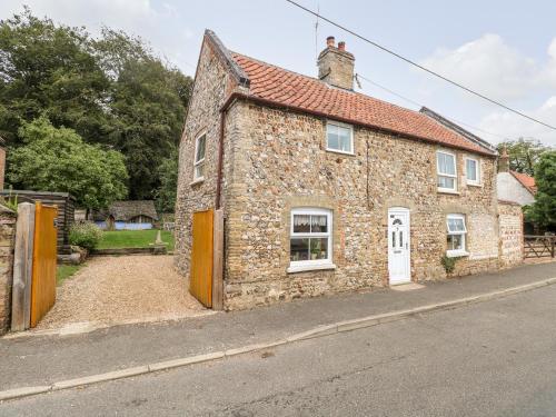 an old stone building with a red roof on a street at Garden House in Thetford