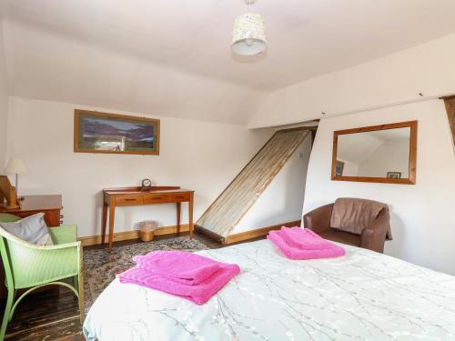 a bedroom with a bed with pink towels on it at Garden House in Thetford